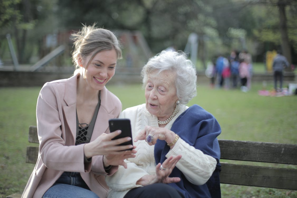 A caregiver helping a senior use their phone.